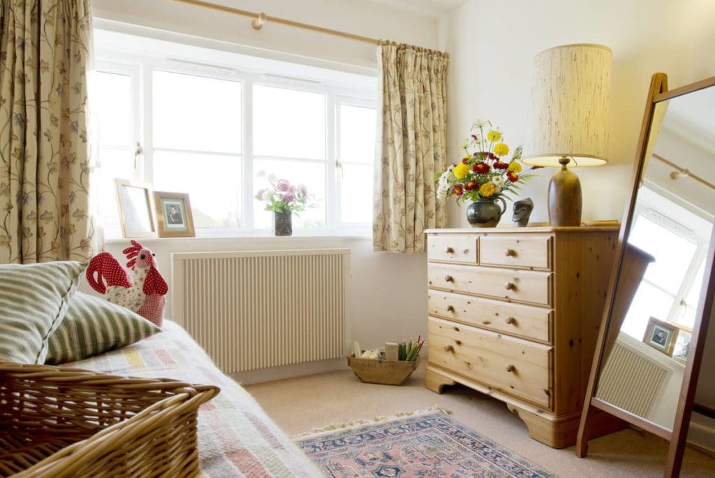 Warm cozy bedroom with radiator heating by South West Heating Solutions.