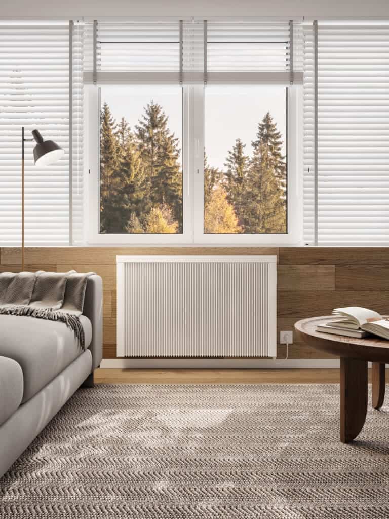 Warm modern interior with white radiator, large window, cozy living space, professional heating solutions.